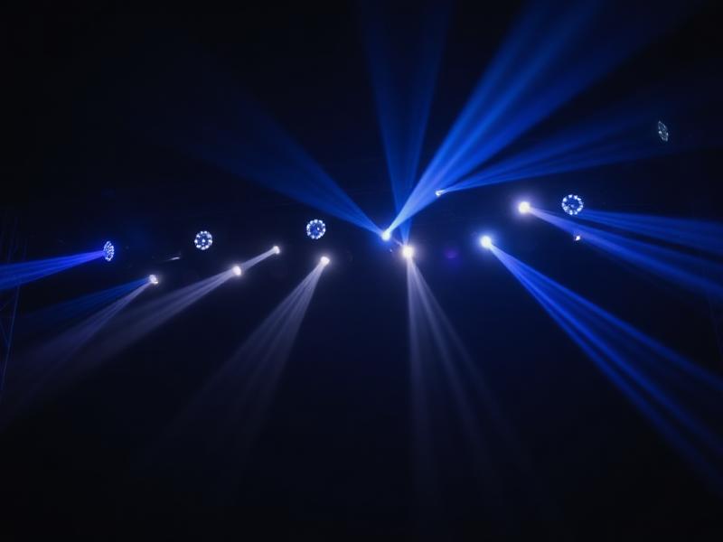 Stage lighting rig with beams cutting through haze